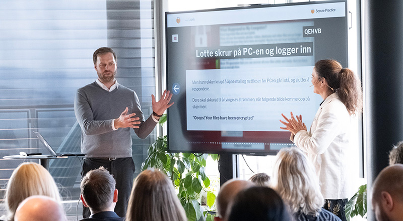 Erlend Gjaere realizando una presentación sobre ciberseguridad ante un grupo de personas